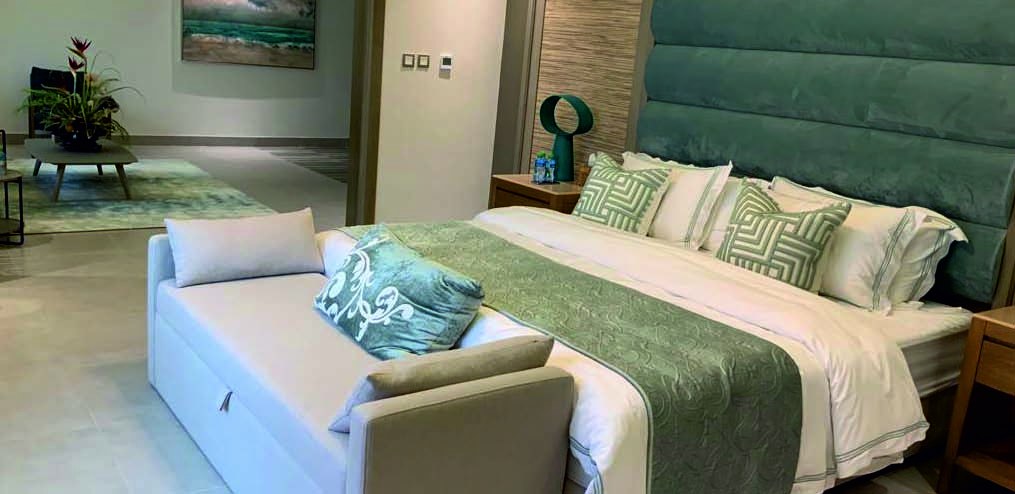 Master suite with upholstered headboard in soft green