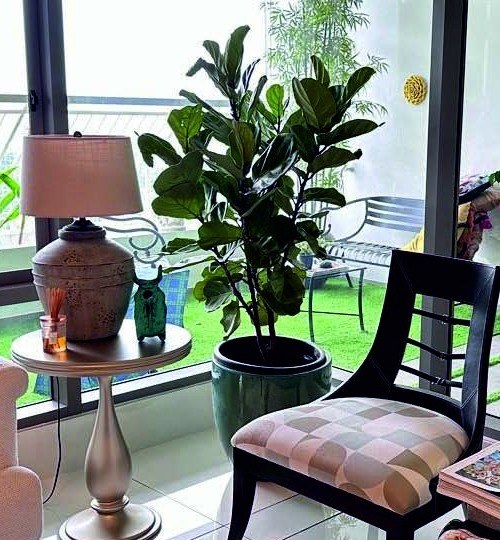 Lacquered chair with patterned seat beside a side table