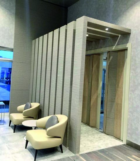 Lift lobby with textured stone portal and lounge chairs