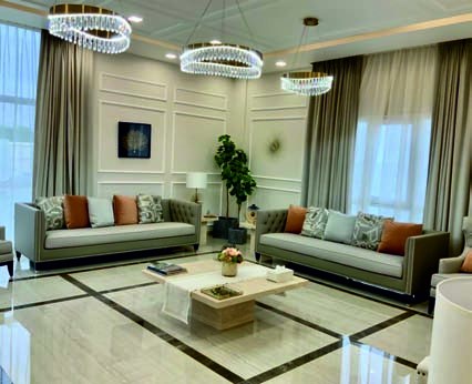 Formal living room with panelled walls and ring chandeliers